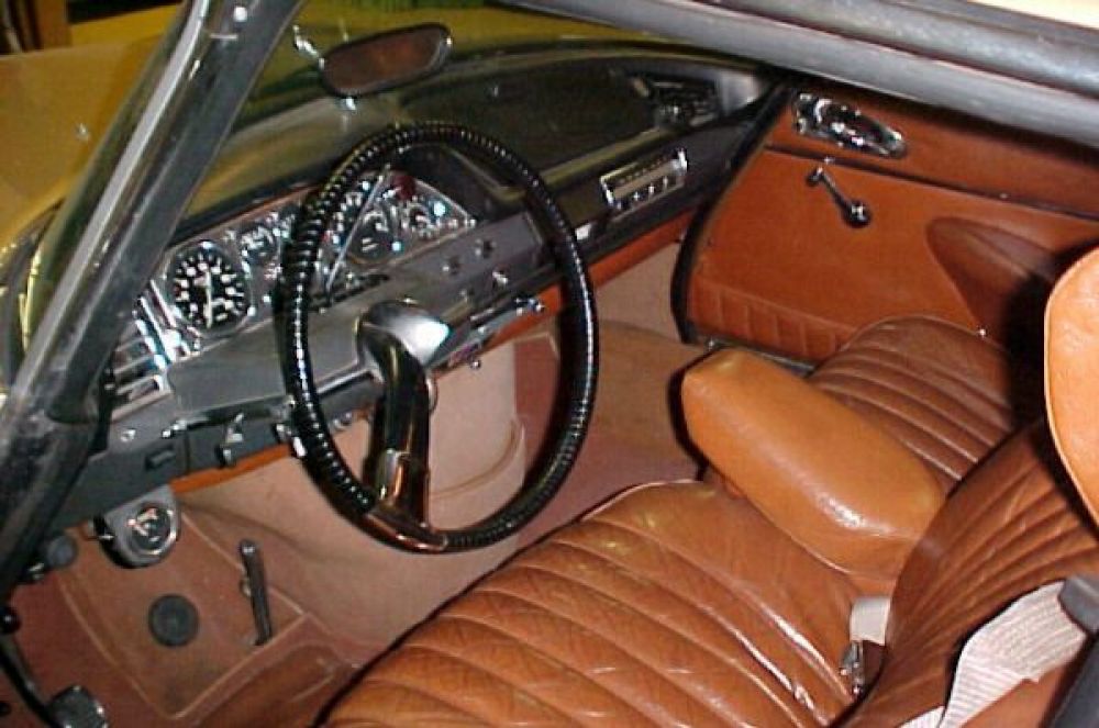 Салон Citroen DS, рулевое колесо с одной спицей, над ним — рычаг переключения передач, внизу видны «палочка» педали газа и «кнопка» педали тормоза, левее — педаль стояночного тормоза.