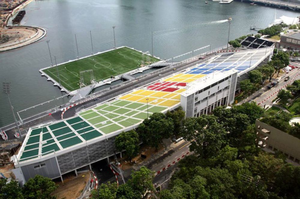 Плавучий стадион в Сингапуре. В городе-государстве земля дорогая, и свободного места для целого футбольного поля на суше не нашлось. Поэтому стадион построили на плавучей платформе в заливе Марина-Бэй. Открытие сооружения состоялось в 2007 году. Основание для него изготовлено из стали, оно имеет длину 120 метров, а ширину - 83 метра. Платформа выдержит вес 9000 человек. Трибуны, которые архитекторы вынесли на берег, вмещают 30 000 зрителей.