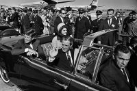 Джон Кеннеди в президентском лимузине покидает аэропорт Далласа.
