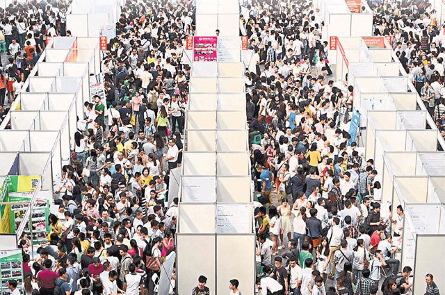 Тысячи китайцев в поисках работы разглядывают павильоны ярмарки вакансий в Чунцине. 