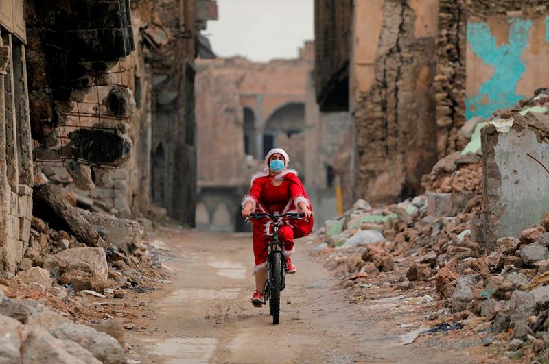 Женщина в костюме Санта-Клауса в Мосуле, Ирак.