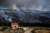 Владелец небольшого домика в Португалии смотрит за распространением лесного пожара.