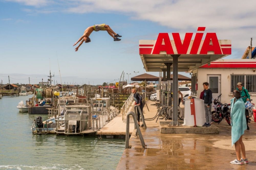 В приморском курортном городке во Франции заправочная станция внезапно превращается в впечатляющую доску для прыжков в воду, с которой несколько мальчишек прыгают в море со смелой и захватывающей дух акробатикой, создавая удивительную и ошеломляющую сцену. 