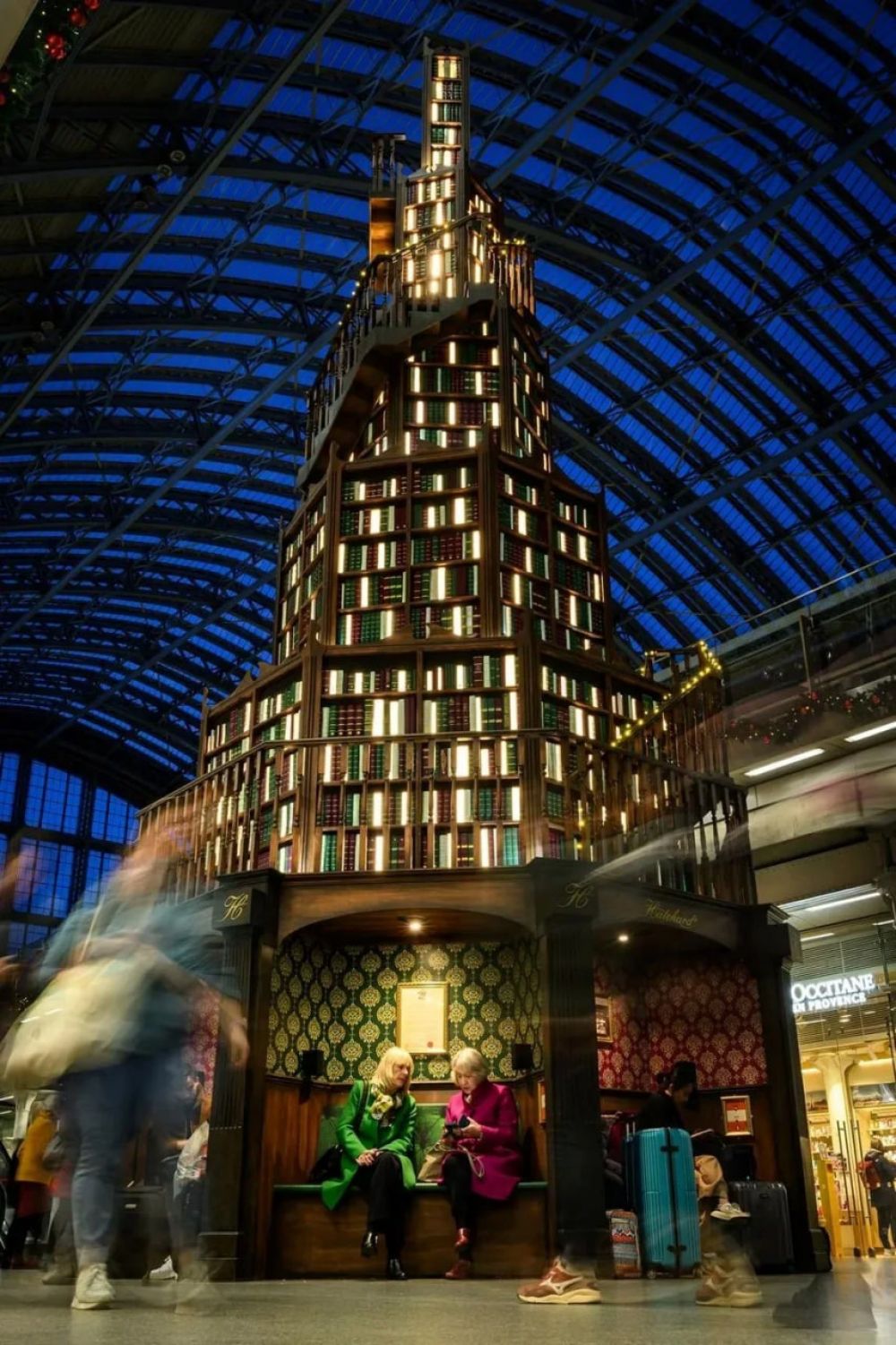 Гигантская книжная полка в форме ёлки установлена на вокзале Сент-Панкрас (Лондон). Кстати, перед вами праздничная реклама книжного магазина.