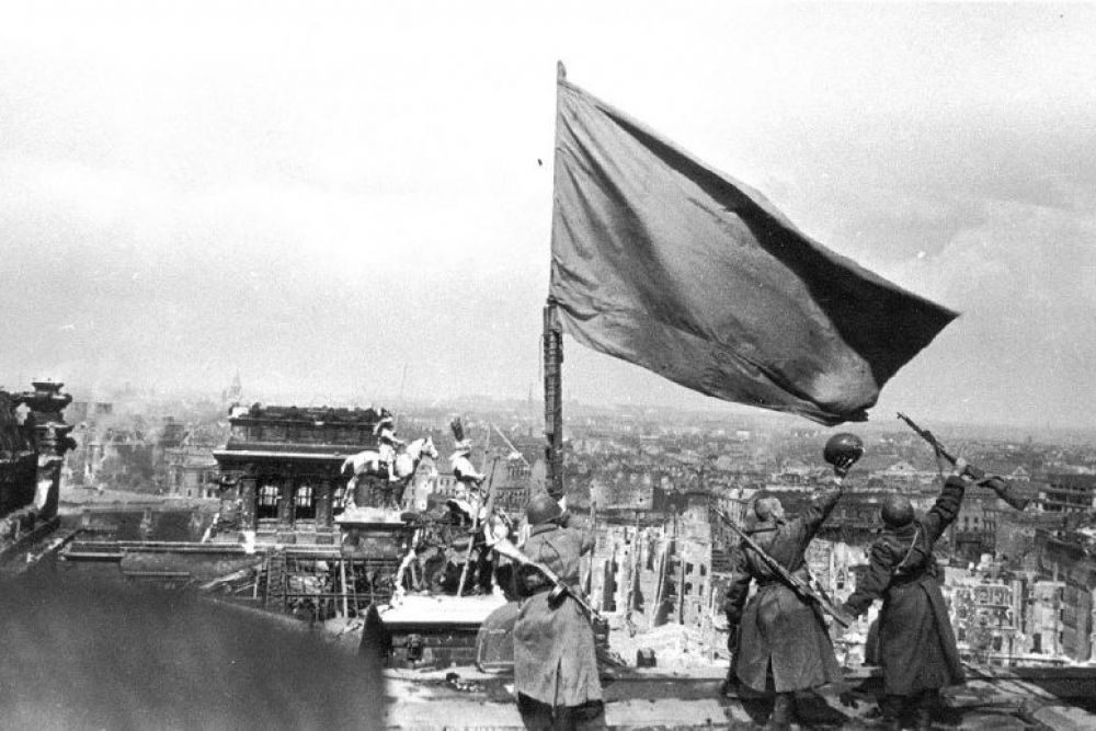 Советские бойцы и одно из знамен, водруженных над Рейхстагом, 1945 год.