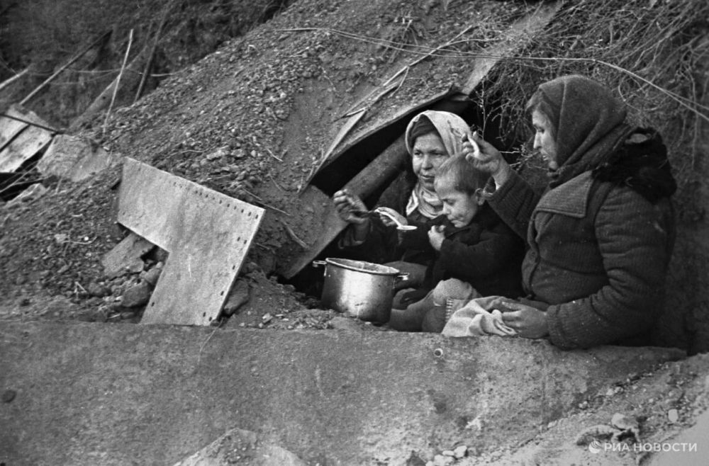 Оставшиеся без крова жители у входа в землянку. Сталинград, 1943 г.