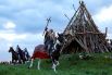 Актёры ездят на лошадях вокруг костра перед тем, как вспыхнет пламя.
