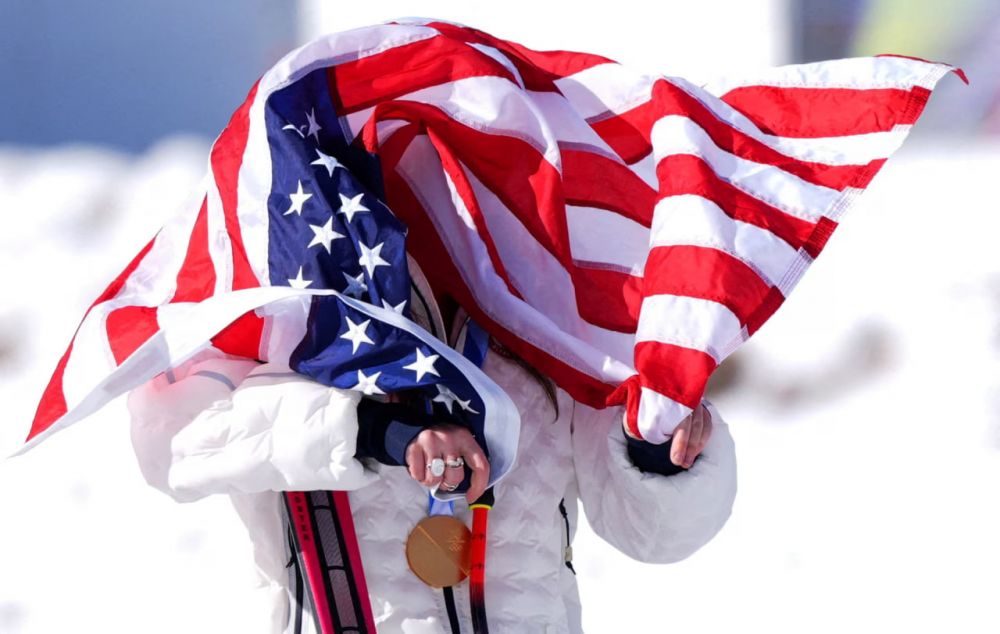 Золотая медалистка Бризи Джонсон из США празднует победу в скоростном спуске.