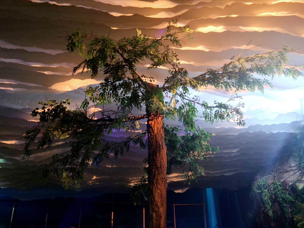 Всё пространство дышит природой. Искусственные деревья тянутся верхушками к небу, а цветы склоняют бутоны к воде - в этом есть особая гармония.