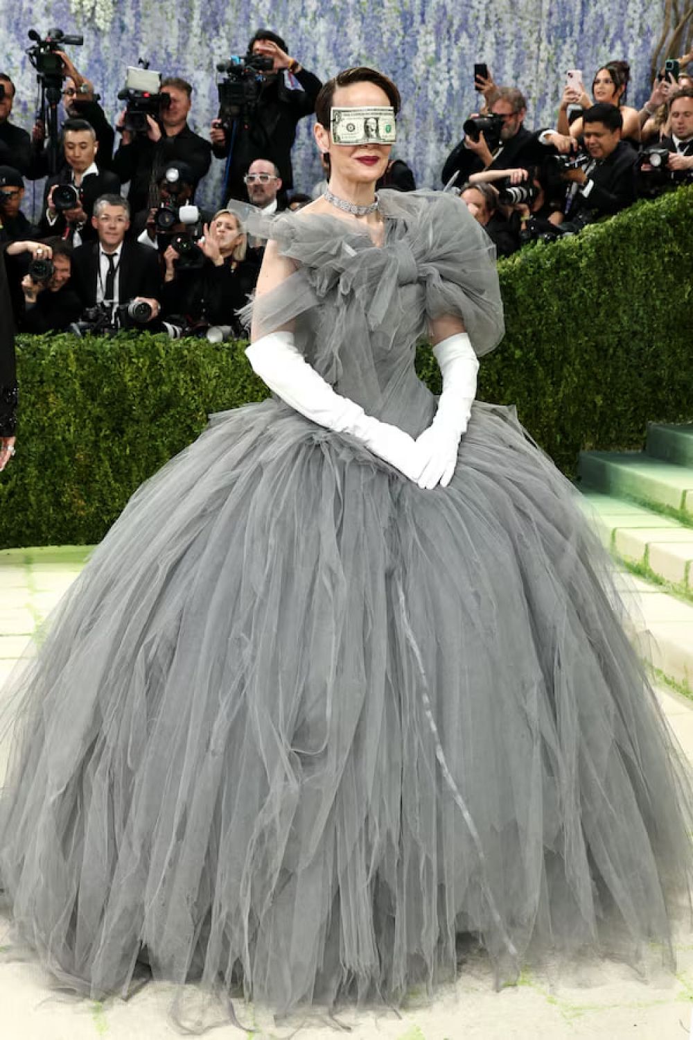 Сара Полсон стала одной из самых обсуждаемых гостей Met Gala после появления в маске из однодолларовой купюры. Многие увидели в этом намёк на сверхбогатых американцев: на Джеффа Безоса и его супругу, которые пожертвовали Институту костюма не менее $10 млн, став одними из главных спонсоров бала. Для многих это стало символом того, что культурное событие можно «купить».